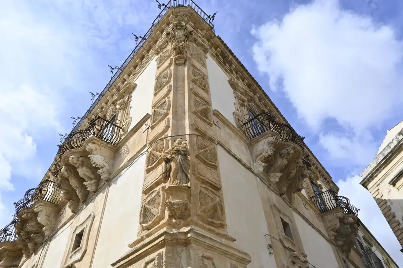 Angolo del palazzo Beneventano a Scicli, con balconi in ferro battuto e decorazioni barocche.