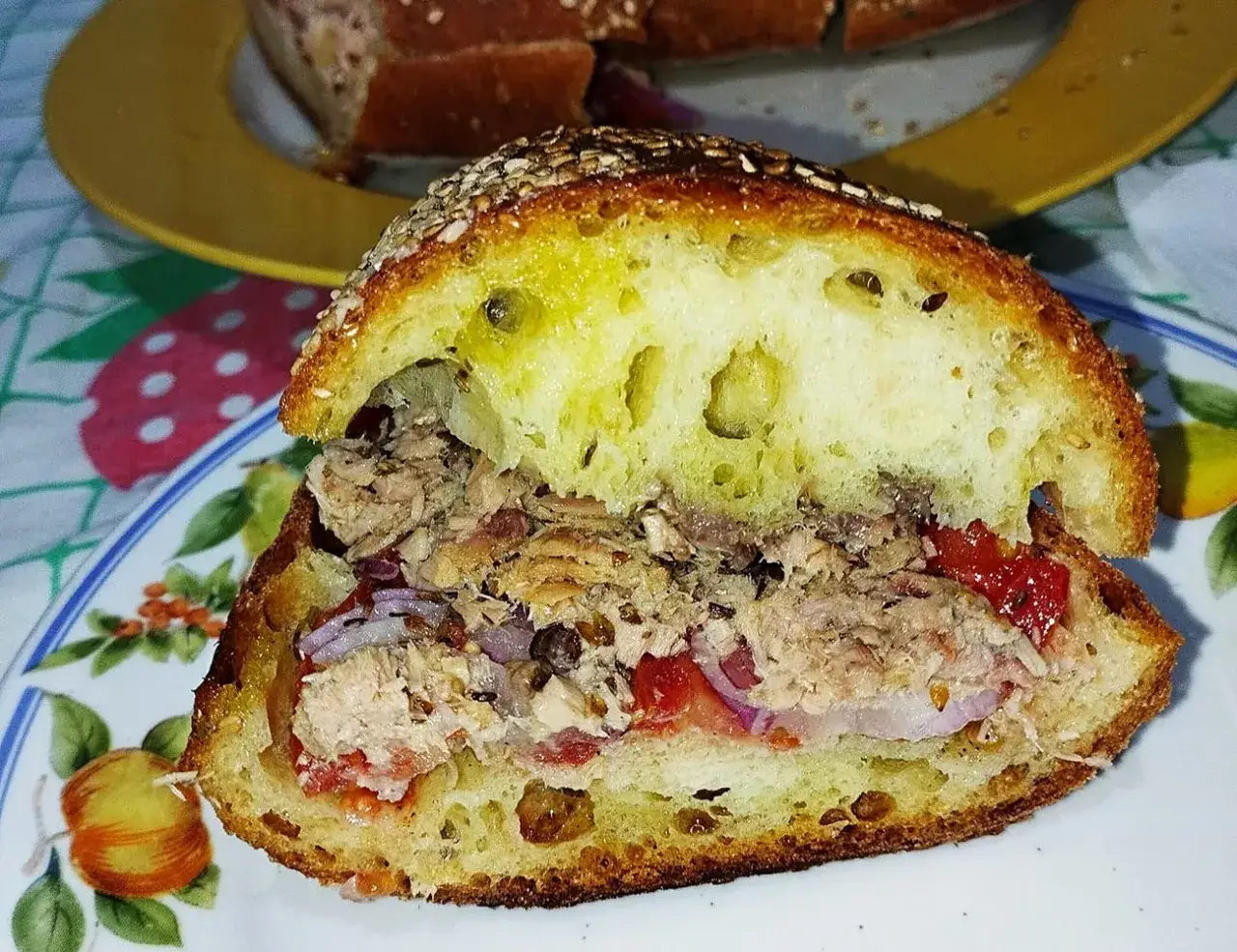 Pane casereccio ripieno di tonno, pomodoro e cipolla rossa, un classico della cucina povera siciliana.