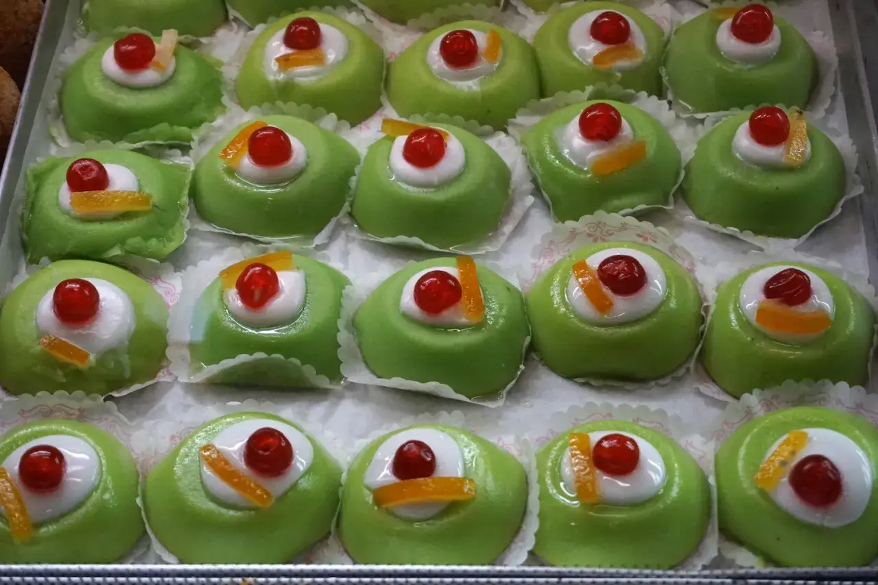 Dolci tipici di Palermo: dolcetti verdi con ciliegina e scorzetta d'arancia candita, un'esplosione di gusto siciliano.