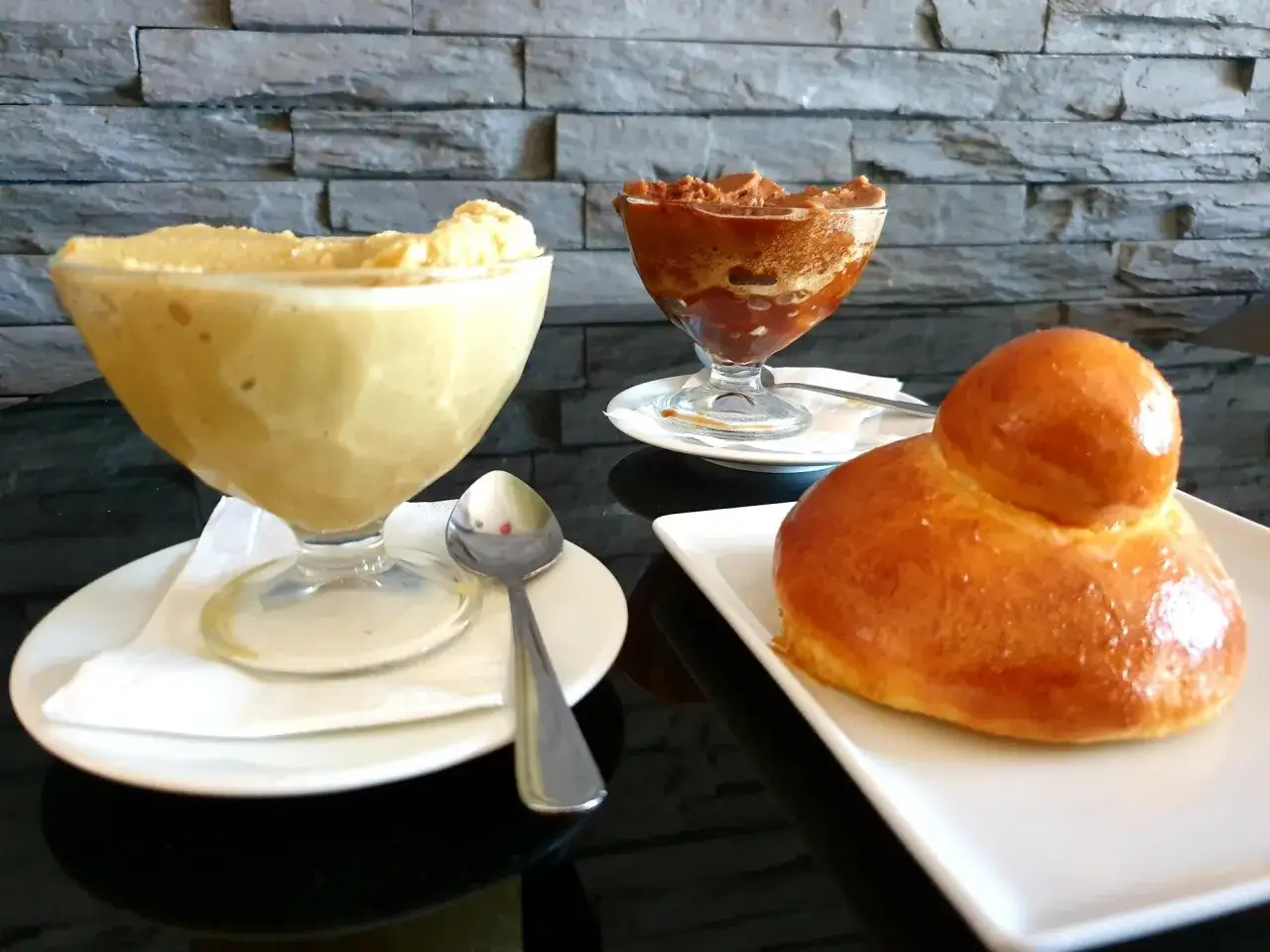 Una deliziosa granita messinese al caff&egrave;, una al cioccolato e un soffice brioche, pronti per essere gustati.