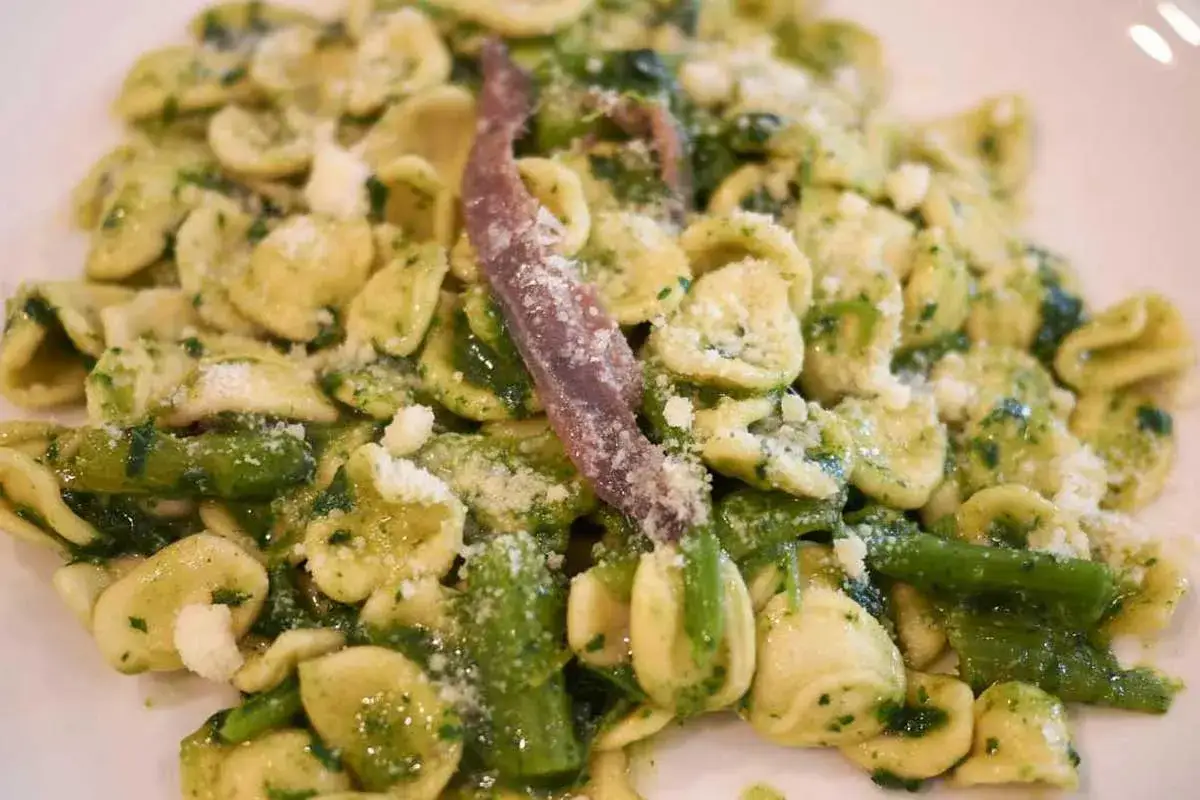 Orecchiette con cime di rapa, un classico dei piatti tipici pugliesi primi, condite con acciughe e formaggio grattugiato.