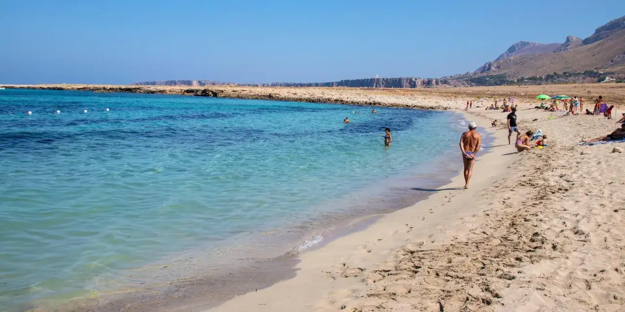 Una giornata di sole alla macari spiaggia, con acque cristalline e gente che si gode il mare.
