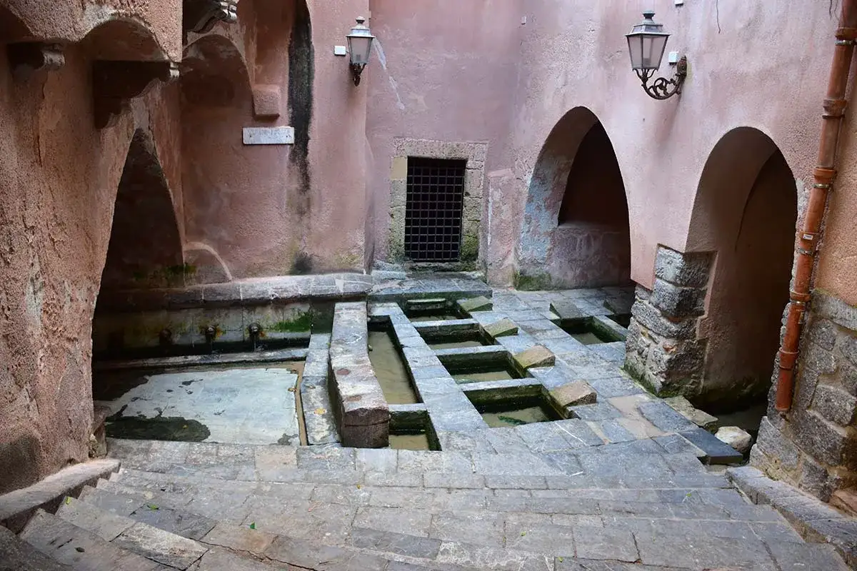Antico lavatoio a Cefal&ugrave;, con vasche in pietra e archi in rosa antico.