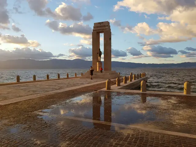 Un tramonto sul lungomare di Reggio Calabria, con il monumento ai caduti e le montagne sullo sfondo. Un luogo perfetto per scoprire cosa fare a Reggio Calabria.