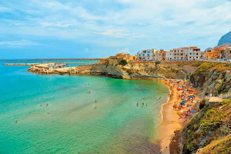 La spiaggia di Terrasini, con la sua scalinata che scende verso il mare cristallino, è un luogo incantevole per godersi il sole e fare il bagno.
